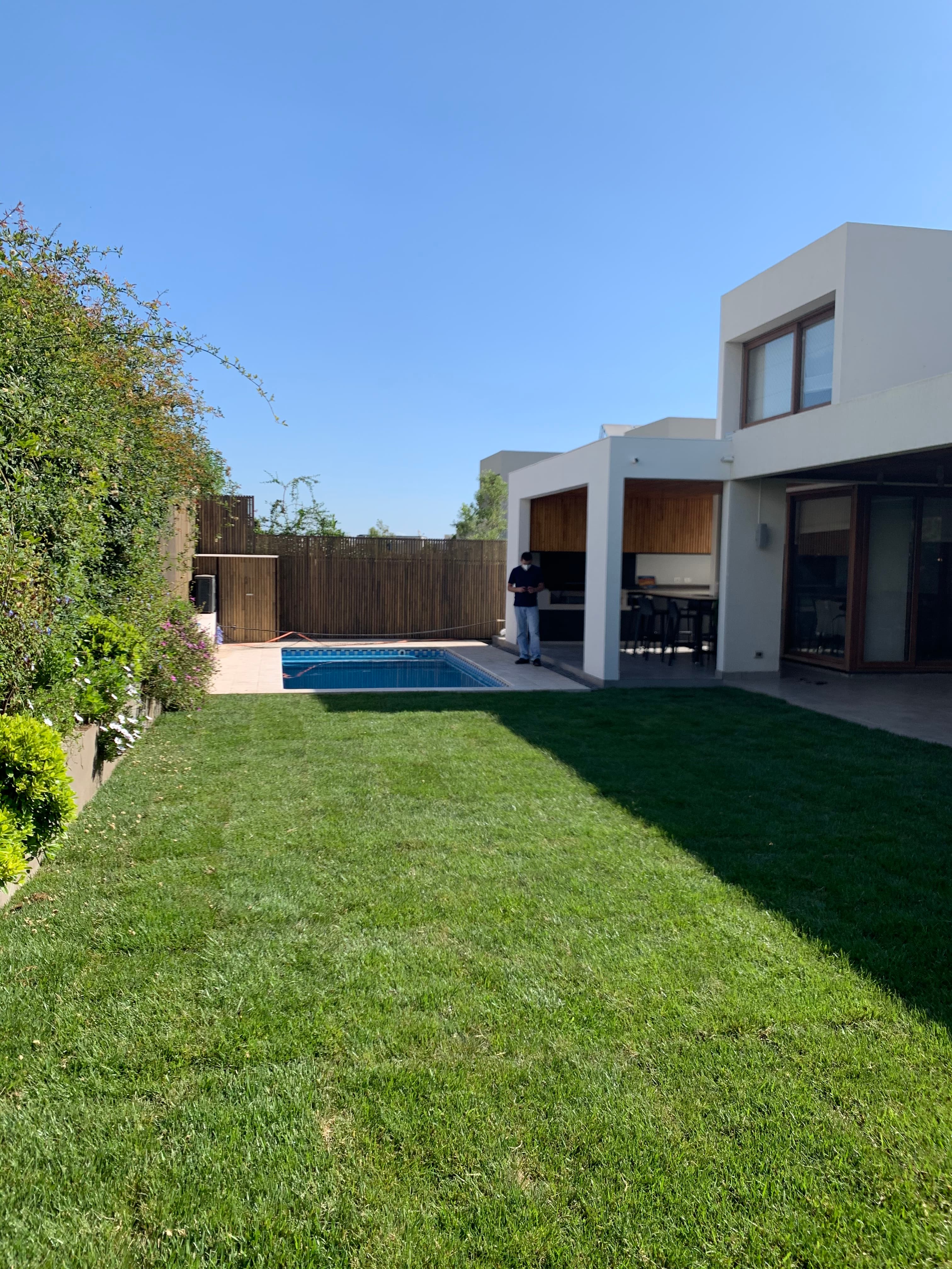 Jardín con piscina y pasto instalado